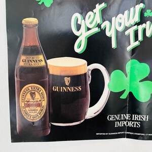 May include: Poster advertising Guinness Extra Stout, featuring a bottle and a pint of the dark stout. The poster includes the text "Get your Irish up" and "Genuine Irish Imports", along with green shamrocks.