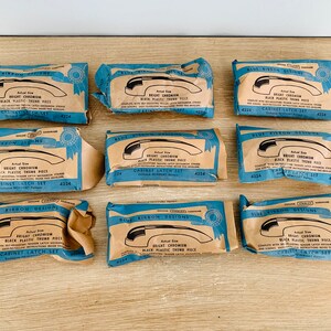 May include: Nine vintage cabinet latch sets, each packaged in blue and tan paper. The packaging features the text "Blue Ribbon Designs" and "Bright Chromium Black Plastic Thumb Piece". The sets are labeled "Cabinet Latch Set".