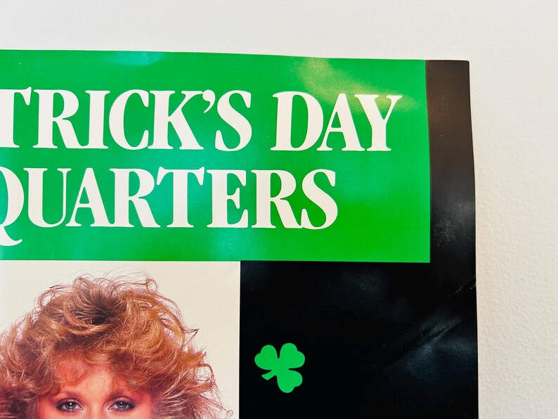 May include: A poster with the words "TRICK'S DAY QUARTERS" in white letters on a green background. A green shamrock is on a black background. A woman with red hair is visible.
