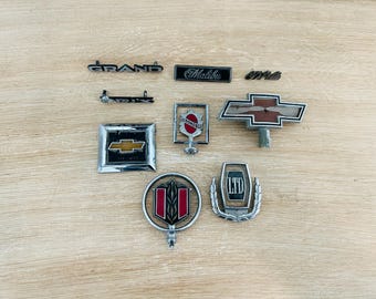 Vintage Original Automotive Parts 1980s 1990s Emblem Badge Oldsmobile Chevy Chevrolet Malibu Pontiac Grand Prix Cadillac DeVille - Lot of 9