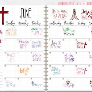 Puede incluir: Una agenda espiral abierta en junio, con una cruz roja y varias pegatinas con frases religiosas como "Jes&uacute;s es el camino" y "Ora". El calendario tiene un dise&ntilde;o de cuadr&iacute;cula con entradas diarias.