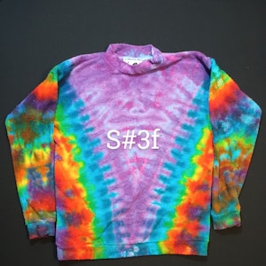 May include: A tie-dye sweatshirt in shades of purple, blue, orange, yellow, and green. The sweatshirt has a crew neck and long sleeves. The text "S#3f" is printed on the front of the sweatshirt.