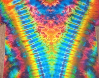 May include: A vibrant tie-dye t-shirt featuring a kaleidoscope of colors, including blue, orange, yellow, and purple. The shirt has a classic crew neck and short sleeves. The tie-dye pattern radiates from the center, creating a psychedelic effect.