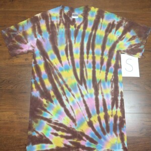 May include: A brown, yellow, blue, and pink tie-dye t-shirt with a swirl pattern. The shirt is size S.