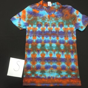 May include: A tie-dye t-shirt with a V-neck and short sleeves. The shirt is a mix of blue, orange, green, and purple colors.