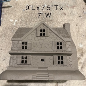 Könnte beinhalten: Ein graues, steintexturiertes Keramikhausmodell mit braunem Dach und Fenstern. Das Haus ist 23 cm lang, 19 cm hoch und 18 cm breit.