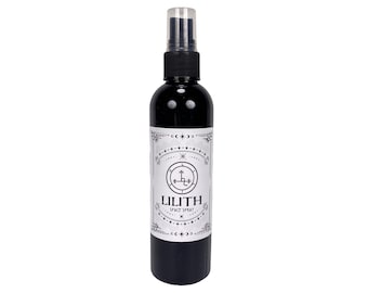 Peut inclure: Une bouteille en verre noir avec un embout pulvérisateur transparent. La bouteille porte une étiquette blanche avec une illustration noir et blanc d'un pentagramme et le texte "Lilith Space Spray".