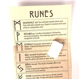 Pode incluir: Um close-up de um papel amarelo com texto e s&iacute;mbolos pretos. O texto diz "RUNES" e lista os nomes e significados de diferentes runas. As runas s&atilde;o representadas em preto.