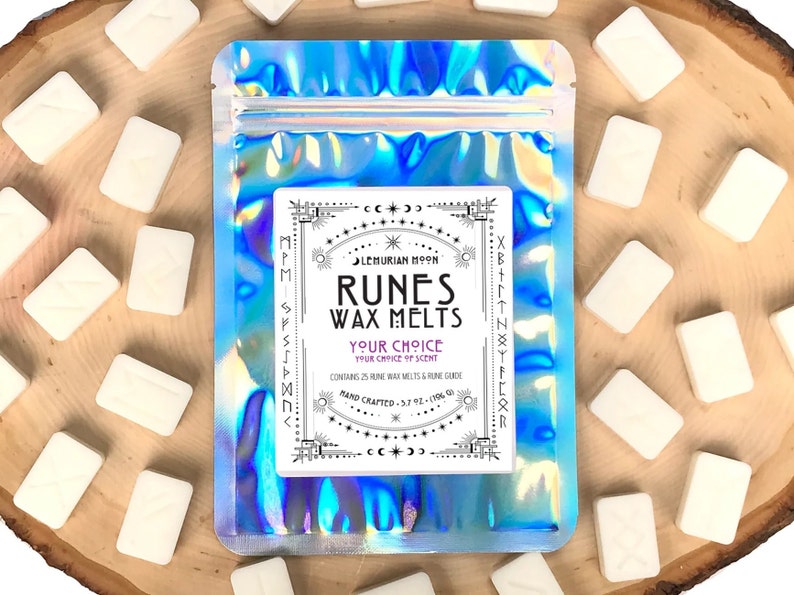 Pode incluir: Uma bolsa hologr&aacute;fica contendo 25 derretimentos de cera branca em forma de runas. A bolsa tem o texto "Lemurian Moon Runes Wax Melts Your Choice Your Choice of Scent Hand Crafted - 5.7 oz - 170g" impresso nela.