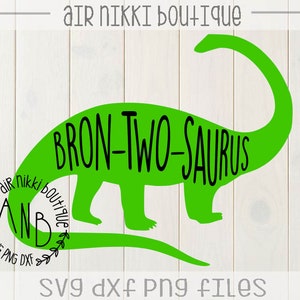 May include: Green silhouette of a Brontosaurus dinosaur with the text "BRON-TWO-SAURUS" on its body. A circle with the text "AIR NIKKI BOUTIQUE" and a wreath design is in the lower left corner. The text "SVG DXF PNG FILES" is at the bottom of the image.