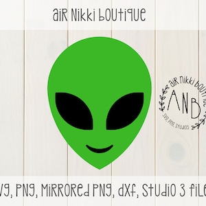May include: Green alien head with black eyes and a smile. The alien head is on a white wood background. The text "air Nikki boutique" is at the top of the image. The text "AND" is in a circle with leaves around it. The text "Svg, png, Studios" is below the circle.