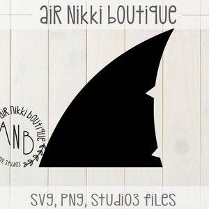 May include: Black silhouette of a shark fin with the text "Air Nikki Boutique" and "ANB SVG, PNG, Studio3 files" on a white wood background.