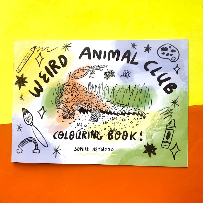 May include: A coloring book cover with a whimsical illustration of a pangolin in a green and yellow jungle setting. The title is "Weird Animal Club Coloring Book!" with the author's name, Sophie Heywood, below.
