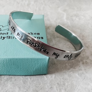 May include: Silver bracelet with the inscription "You are my sunshine, my only sun".