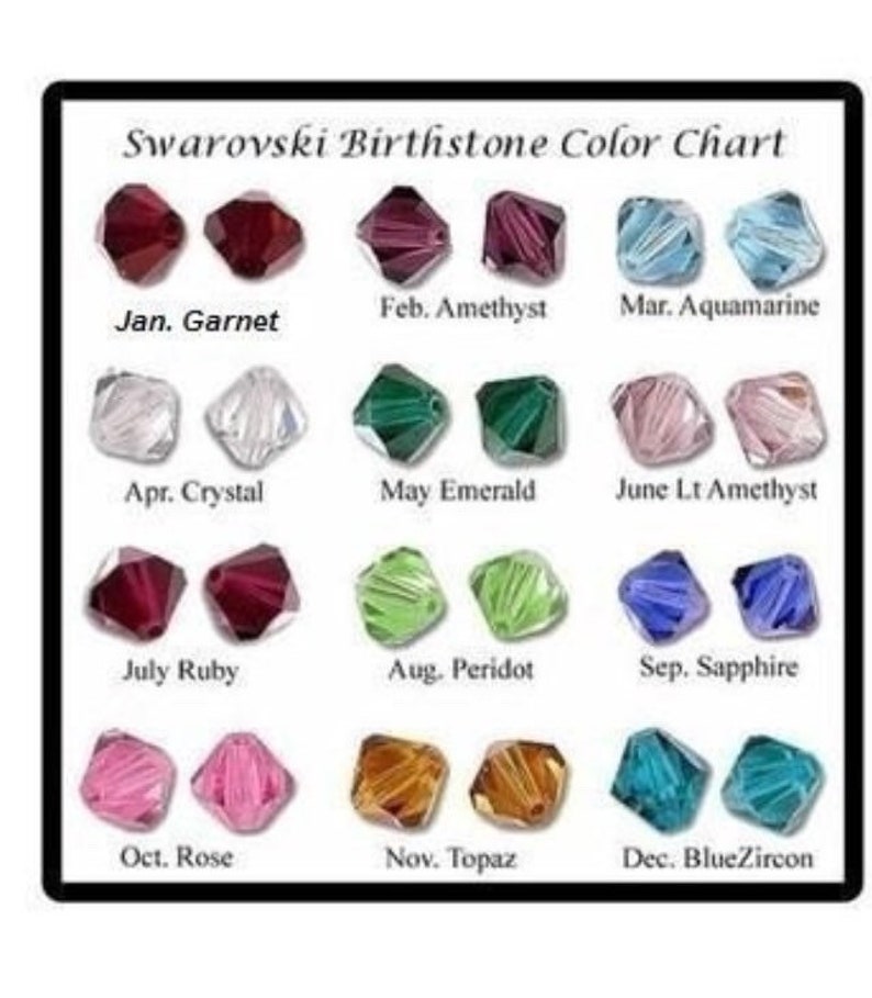 May include: A chart showing the Swarovski birthstone colors for each month of the year. The chart shows a pair of small, faceted crystals for each month, with the month and birthstone name listed below each pair. The birthstones are: Garnet, Amethyst, Aquamarine, Crystal, Emerald, Light Amethyst, Ruby, Peridot, Sapphire, Rose, Topaz, and Blue Zircon.