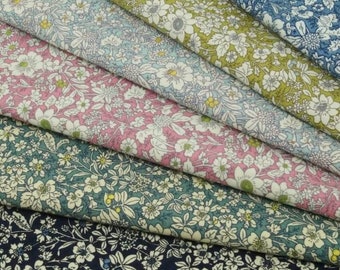 May include: A stack of five different floral patterned fabrics. The fabrics are in shades of blue, green, pink, and yellow. The patterns are all small and delicate.