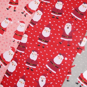 May include: Red and pink fabric with a repeating pattern of white hearts and Santa Claus figures. The Santa Claus figures are wearing red suits with white trim and black belts. The fabric is perfect for crafting projects, quilting, and sewing.