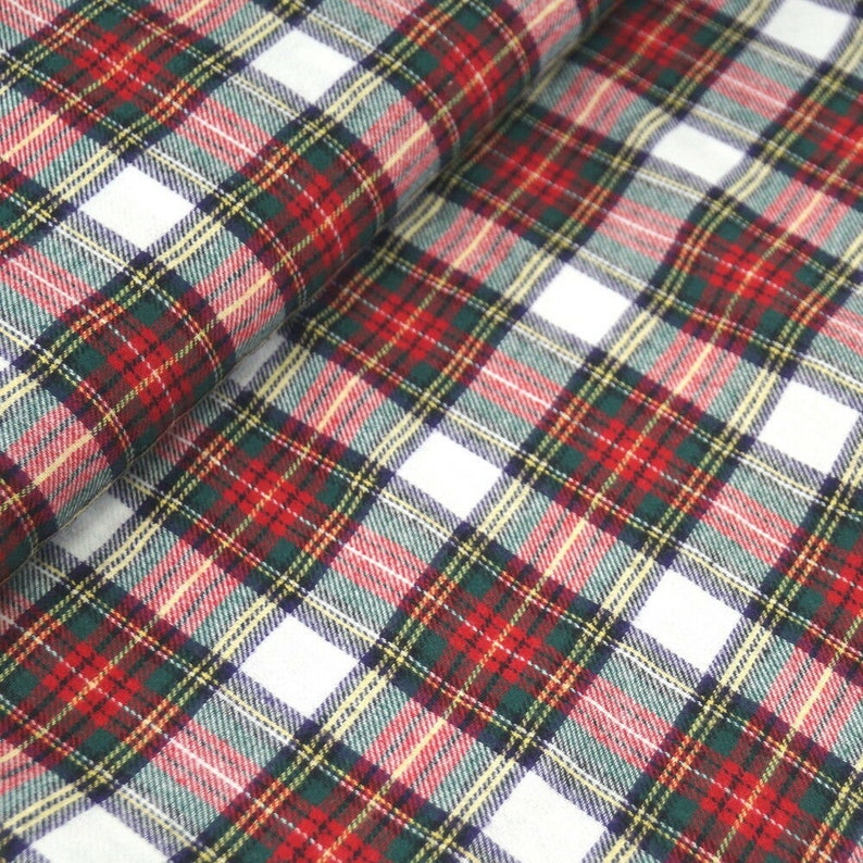 May include: Red, green, white, and yellow plaid fabric with a woven texture.