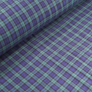 May include: A close-up of a blue and green plaid fabric. The fabric has a soft, textured feel and is perfect for sewing projects.