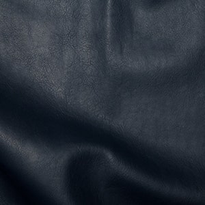May include: Close-up of a dark blue textured fabric with a wrinkled surface.