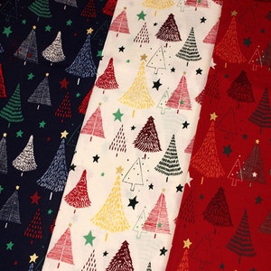 May include: Three fabric swatches featuring different Christmas tree designs. The first swatch is navy blue with white and green trees. The second swatch is white with red, yellow, and black trees. The third swatch is red with black and white trees.