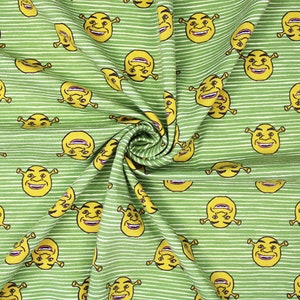 May include: Green and white striped fabric with a repeating pattern of yellow Shrek faces.