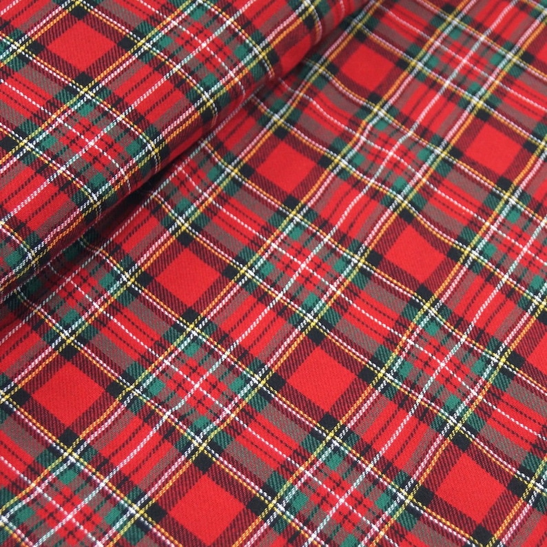 May include: Red, green, white, and black plaid fabric with a woven texture.