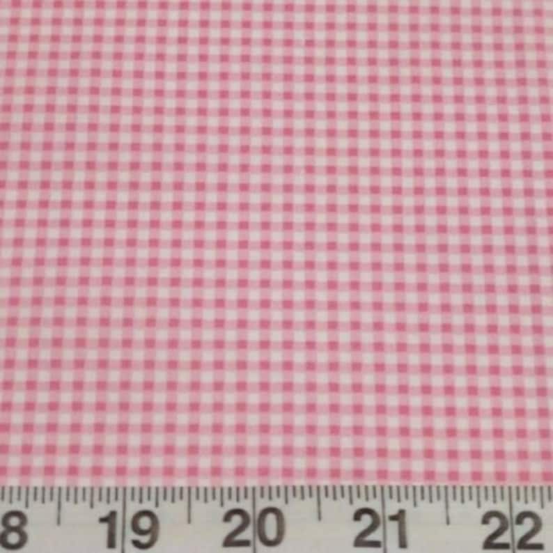 K&ouml;nnte beinhalten: Rosa-wei&szlig;es Gingham-Gewebe mit kleinem Karomuster. Der Stoff wird mit einem Lineal gemessen, das 20 Zoll anzeigt.