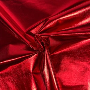 Puede incluir: Primer plano de una tela roja brillante con un acabado met&aacute;lico. La tela est&aacute; doblada y drapeada, mostrando su textura y brillo.