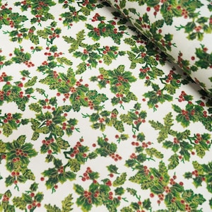 May include: White wrapping paper with a repeating pattern of green holly leaves and red berries. The holly leaves have a gold glitter finish.