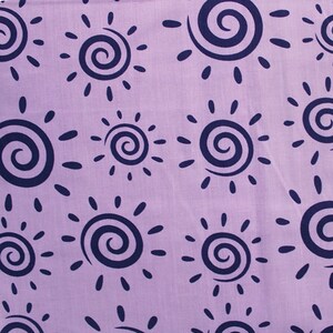 May include: Purple fabric with a repeating pattern of navy blue stylized suns with a spiral in the center.