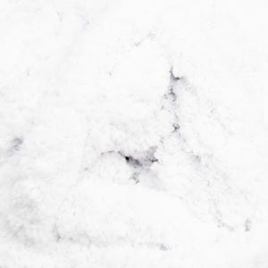 May include: A close-up shot of a white, fluffy, textured surface. The texture appears soft and cloud-like, with subtle variations in tone and depth. The overall impression is one of gentle, light, and airy softness.