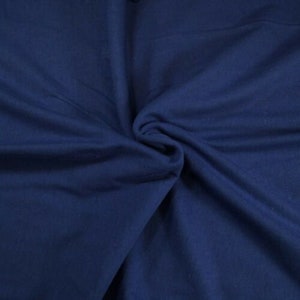 May include: A close-up of a smooth, dark blue fabric. The fabric is folded and draped, showing its texture and color.