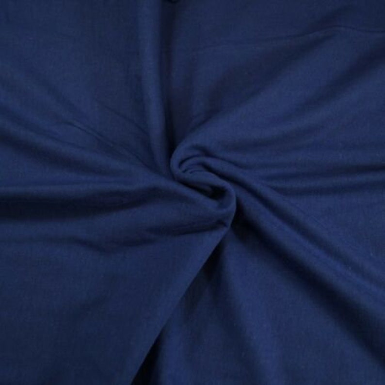 May include: A close-up of a smooth, dark blue fabric. The fabric is folded and draped, showing its texture and color.