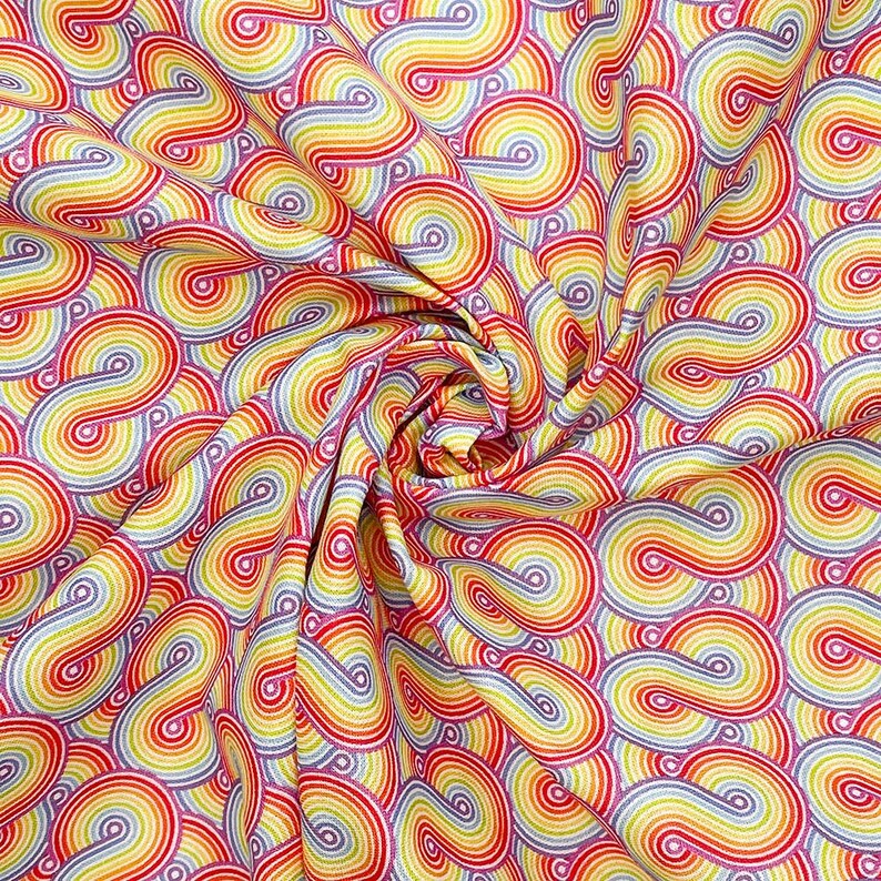 May include: A fabric with a repeating pattern of rainbow-colored swirls. The swirls are made up of red, orange, yellow, green, blue, indigo, and violet stripes. The fabric is white with a subtle shimmer.