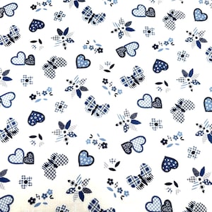 May include: A white background with a repeating pattern of blue butterflies, hearts, and flowers. The design is made up of patchwork pieces in various shades of blue.