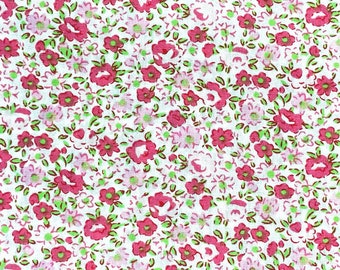 May include: A white fabric with a repeating pattern of small pink and green flowers. The fabric has a subtle texture.