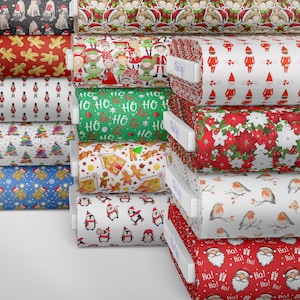 K&ouml;nnte beinhalten: Ein Stapel Stoffrollen mit verschiedenen Weihnachtsmotiven, darunter Pinguine, Lebkuchenm&auml;nner, Elfen und Weihnachtsmann. Der Stoff ist wei&szlig; mit roten, gr&uuml;nen und blauen Akzenten.