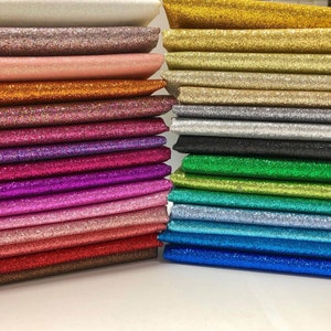May include: A stack of 20 different colored glitter fabric sheets. The colors include white, silver, gold, pink, orange, red, purple, blue, green, and black.