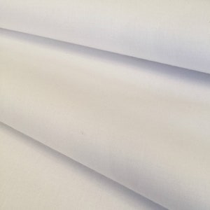 May include: White fabric with a smooth texture. The fabric is folded in half, showing the inside and outside of the material.