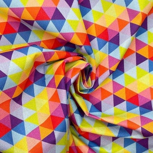 Op de afbeelding: Een kleurrijke stof met een geometrisch patroon van driehoeken in tinten blauw, geel, oranje, roze en paars.