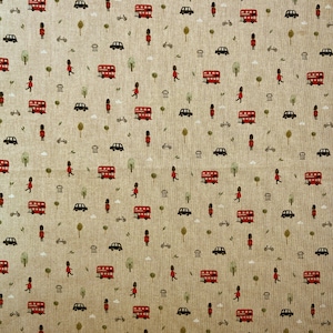 May include: A beige fabric featuring a repeating pattern of red London buses, black cars, guards in red coats, bicycles, trees, and small buildings. The design has a whimsical, travel-themed aesthetic.