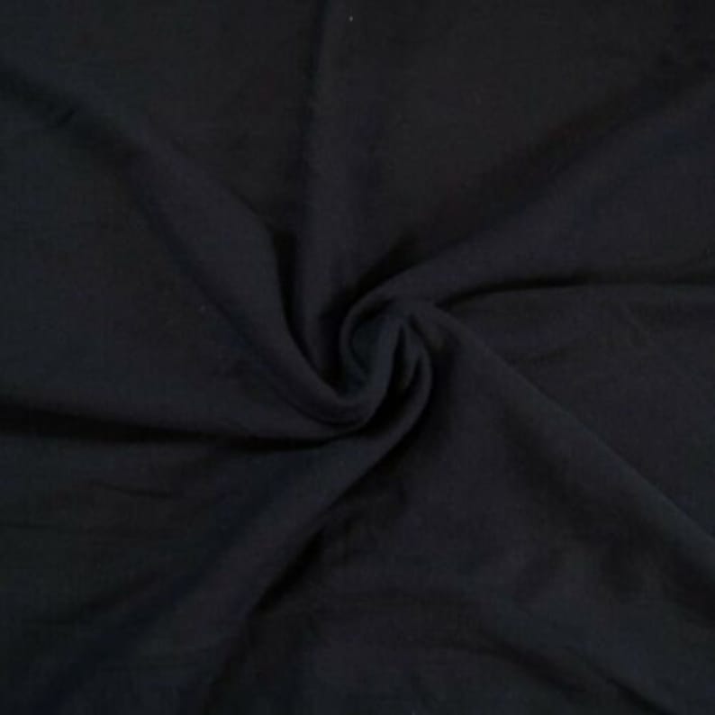 May include: A close-up of a black fabric with a soft, smooth texture. The fabric is folded and draped, creating a sense of depth and dimension.