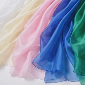 a variety of colorful silks, including white, pink, blue, and green, arranged in a visually appealing manner.