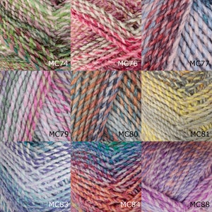 Op de afbeelding: Een verzameling garenklossen in verschillende kleurcombinaties, waaronder groen, roze, rood, blauw, geel en paars. Elke klos is gelabeld met een code, zoals MC74, MC76, MC79, enzovoort.