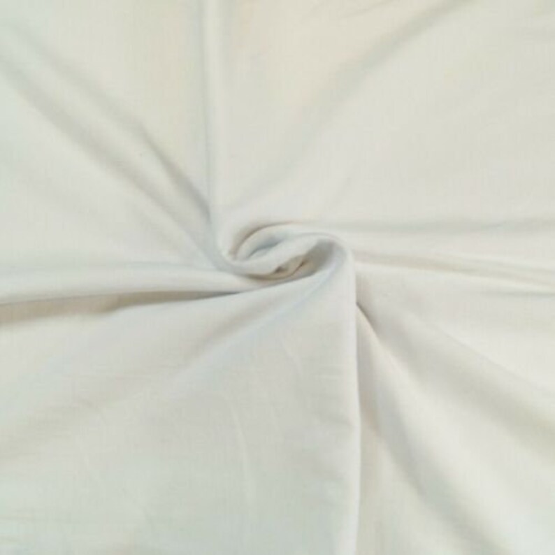 May include: A close-up of a white fabric with a smooth texture. The fabric is folded and draped, showing its soft and flowing nature.