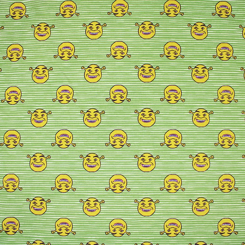 May include: A green and white striped fabric with a repeating pattern of yellow cartoon faces. The faces have green skin, large eyes, and a wide smile.