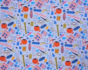 May include: A blue fabric with a repeating pattern of sewing supplies. The pattern includes buttons, spools of thread, needles, scissors, thimbles, and measuring tapes. The fabric is perfect for crafting projects.