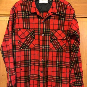 May include: Red and black plaid flannel shirt with long sleeves and a button-up front.