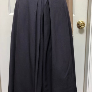 May include: A dark gray pleated skirt with a high waist and a flared hem.